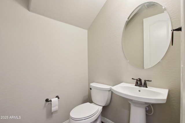 bathroom with toilet and vaulted ceiling