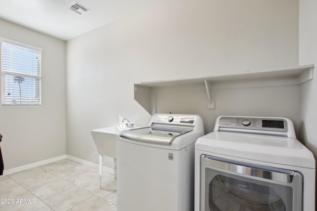 washroom featuring sink, washing machine and clothes dryer, and light tile patterned floors