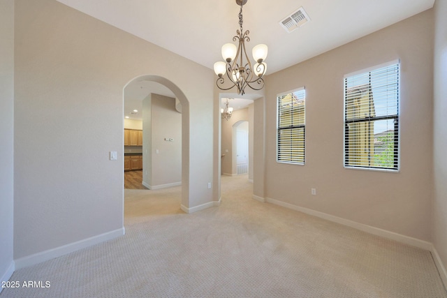 20750 N 87th St Unit 2062, Scottsdale, AZ 85255 - empty room featuring arched walkways, a chandelier, light colored carpet, and baseboards