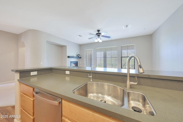 20750 N 87th St Unit 2062, Scottsdale, AZ 85255 - kitchen with dishwasher, a sink, a glass covered fireplace, ceiling fan, and wood finished floors