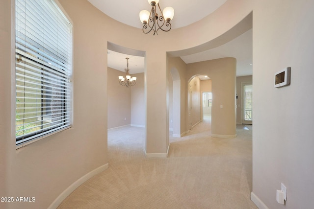 20750 N 87th St Unit 2062, Scottsdale, AZ 85255 - corridor featuring a chandelier, arched walkways, carpet flooring, and baseboards