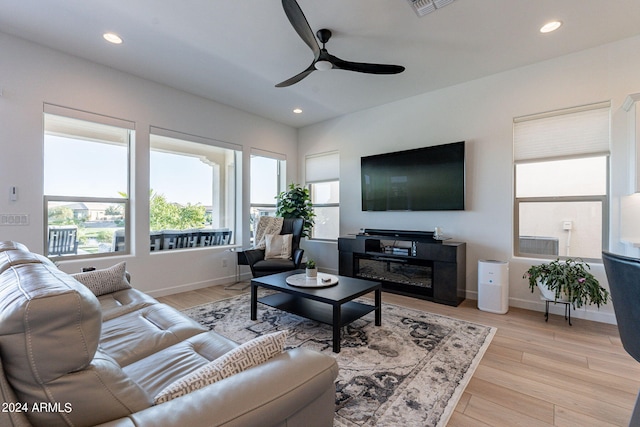 living room with ceiling fan and light wood-type flooring