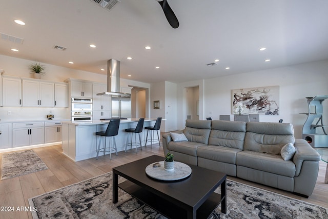 living room featuring light hardwood / wood-style flooring and ceiling fan