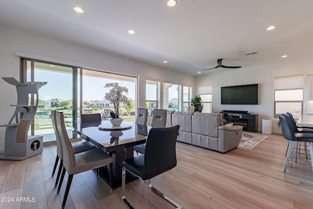 dining space with light hardwood / wood-style flooring and ceiling fan