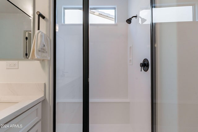 bathroom featuring walk in shower and vanity