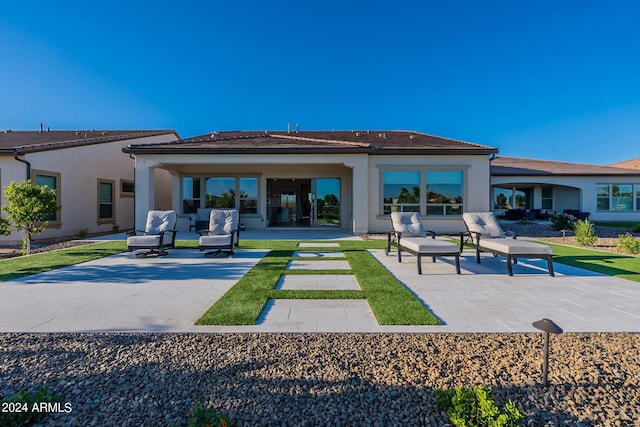 back of property with a patio and an outdoor living space