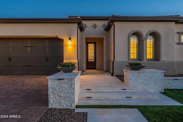 exterior entry at dusk with a garage