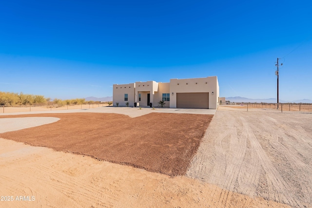 pueblo-style home with a rural view and a garage