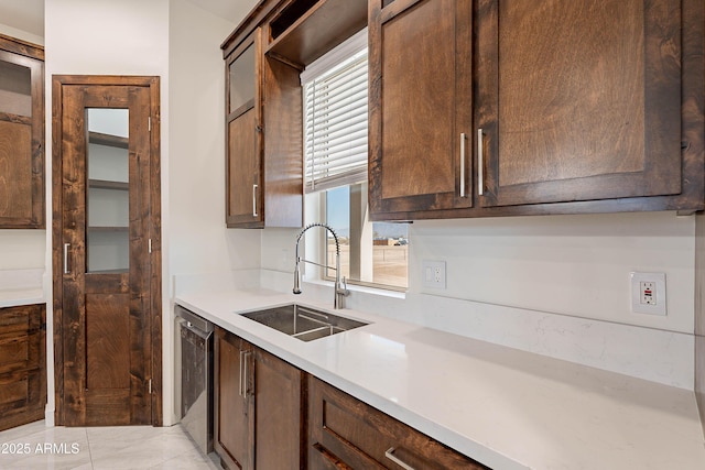 kitchen featuring sink, stainless steel dishwasher, and dark brown cabinets