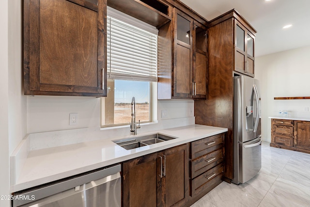 kitchen featuring appliances with stainless steel finishes, dark brown cabinets, and sink