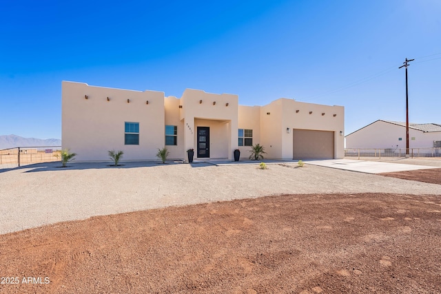 pueblo-style home with a mountain view and a garage