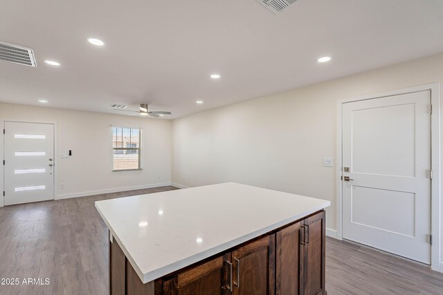 kitchen with ceiling fan, light hardwood / wood-style flooring, and a center island