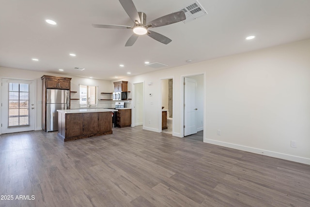 kitchen with stainless steel fridge, a center island, dark hardwood / wood-style floors, and ceiling fan