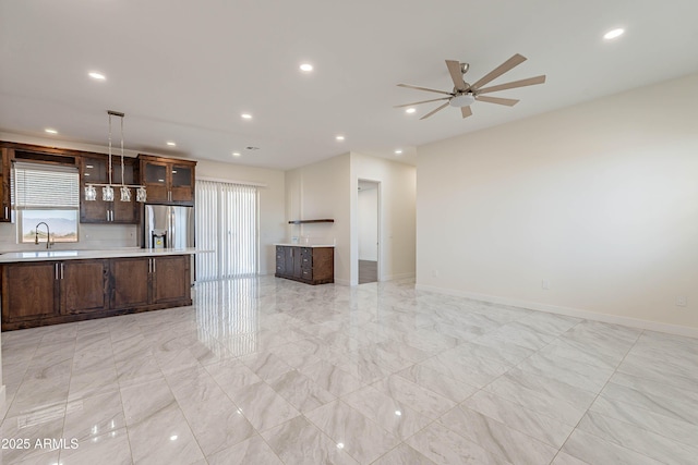 unfurnished living room with ceiling fan and sink