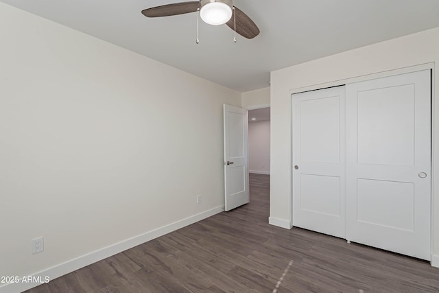 unfurnished bedroom featuring ceiling fan, dark hardwood / wood-style floors, and a closet