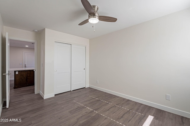 unfurnished bedroom with ceiling fan, a closet, and hardwood / wood-style flooring