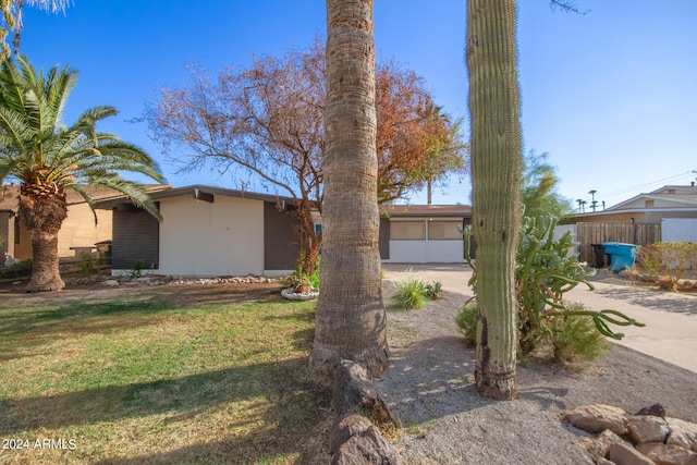 ranch-style house with a garage and a front lawn