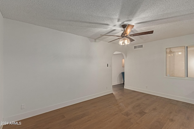 unfurnished room featuring ceiling fan, dark wood-type flooring, and a textured ceiling