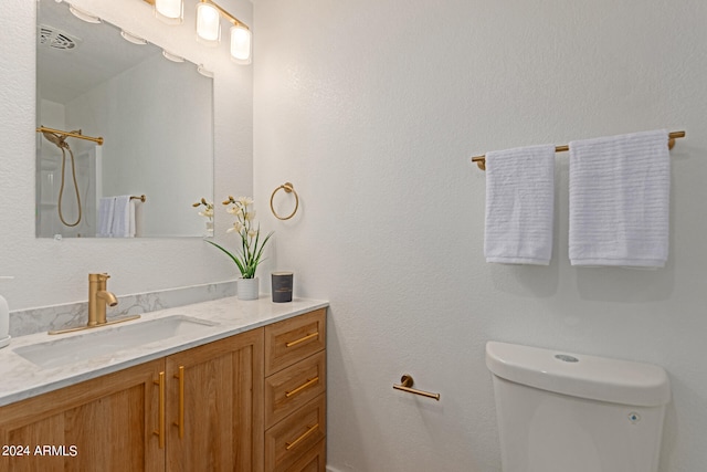 bathroom with walk in shower, vanity, and toilet