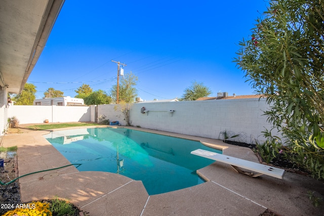 view of swimming pool featuring a diving board