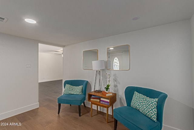 sitting room with ceiling fan and hardwood / wood-style flooring