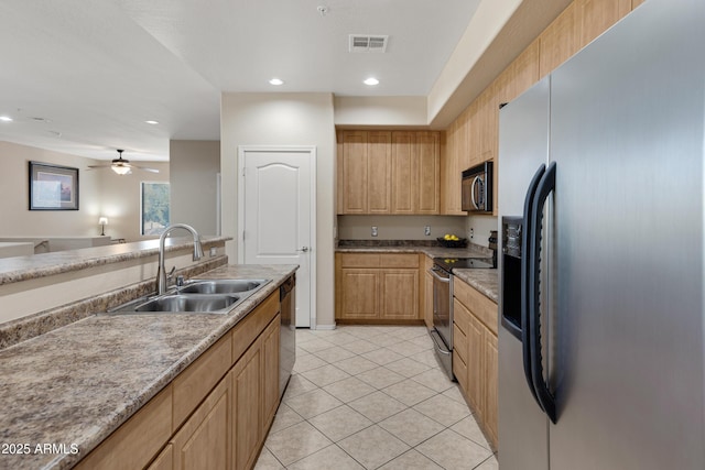 kitchen with light tile patterned floors, stainless steel appliances, visible vents, light brown cabinets, and a sink