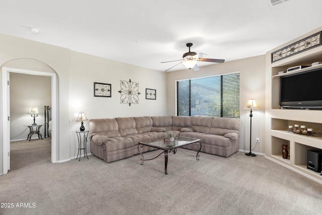 carpeted living room featuring ceiling fan, baseboards, and built in features