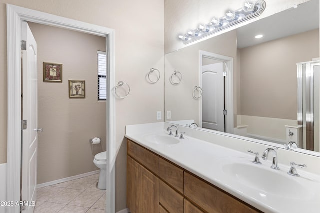 bathroom featuring tile patterned flooring, a sink, toilet, and double vanity