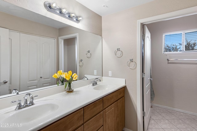 full bath featuring tile patterned flooring, a sink, baseboards, and double vanity