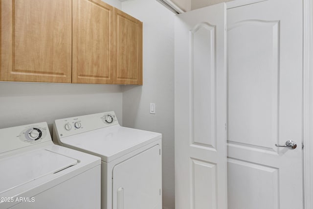 laundry room with washing machine and clothes dryer and cabinet space