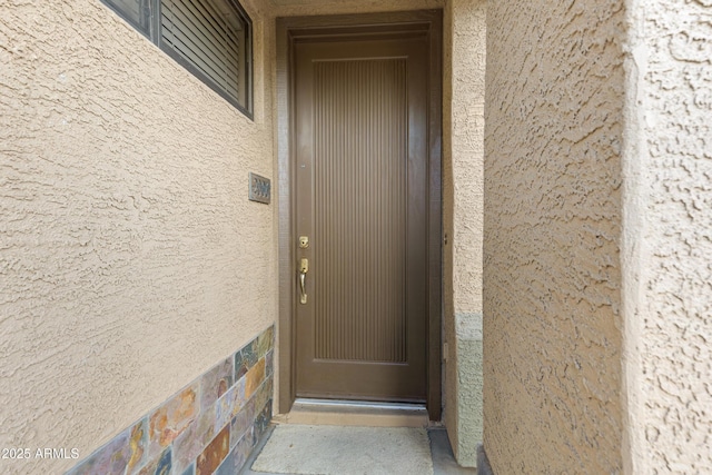 view of exterior entry with stucco siding