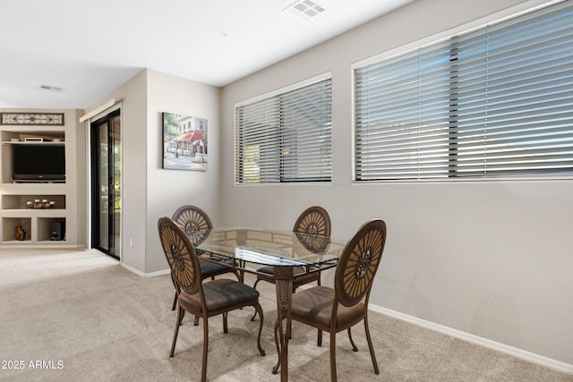 dining space with light colored carpet, plenty of natural light, and visible vents