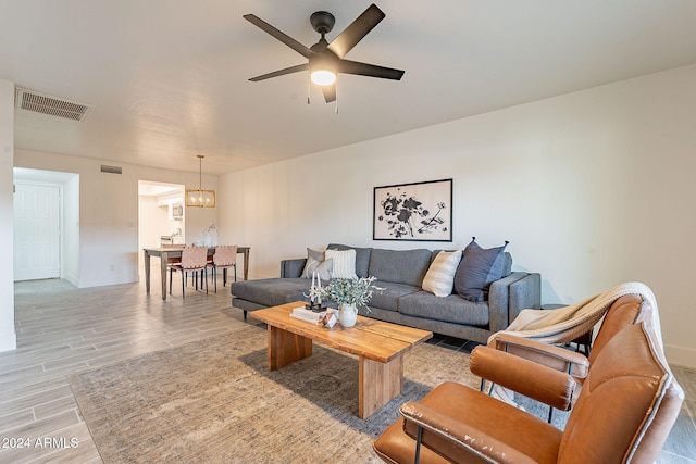 living room featuring ceiling fan with notable chandelier