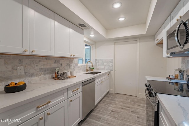 kitchen featuring white cabinets, appliances with stainless steel finishes, and sink