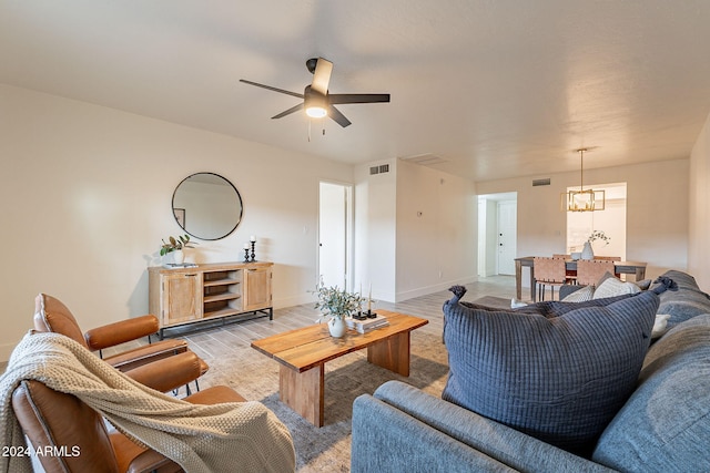 living room featuring ceiling fan with notable chandelier