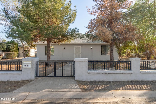 view of front of house featuring a fenced front yard, a gate, and stucco siding