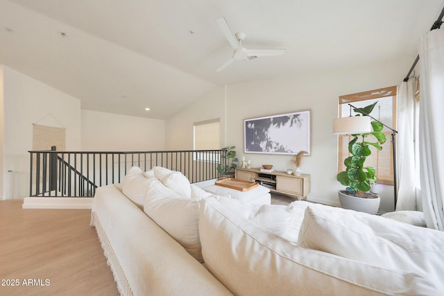 living room featuring ceiling fan, vaulted ceiling, and light hardwood / wood-style flooring