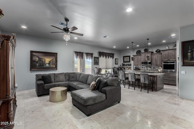 living room featuring ceiling fan and sink