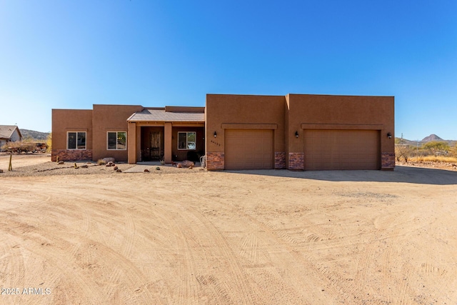 pueblo-style home featuring a garage