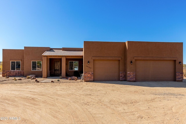 pueblo revival-style home with a garage