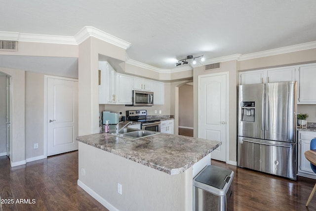 869 W Shellfish Dr, Gilbert, AZ 85233 - kitchen with stainless steel appliances, arched walkways, crown molding, white cabinets, and dark wood-style flooring