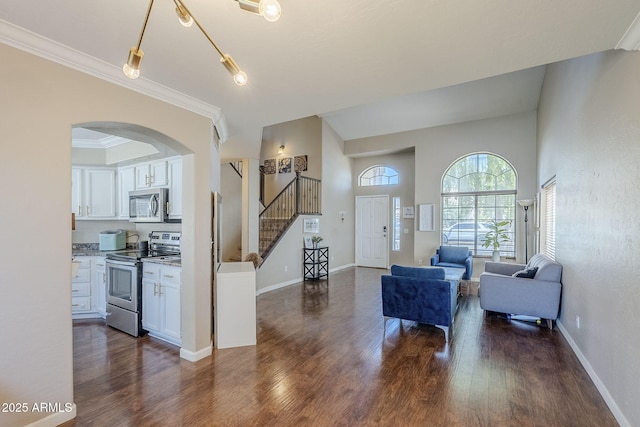 869 W Shellfish Dr, Gilbert, AZ 85233 - living area featuring dark wood-type flooring, arched walkways, stairway, crown molding, and baseboards
