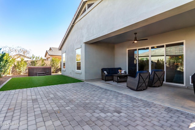 view of patio featuring a hot tub, an outdoor hangout area, and ceiling fan