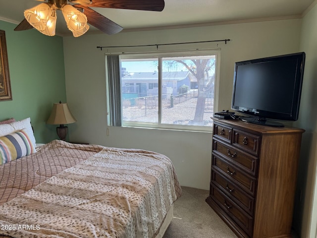 bedroom featuring light carpet, crown molding, and ceiling fan