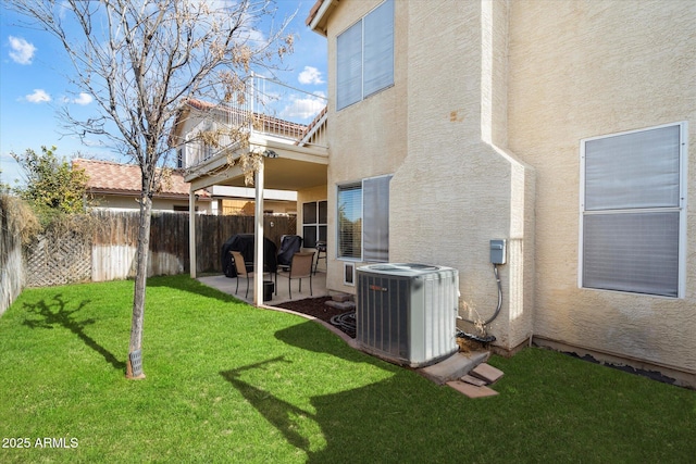 rear view of house featuring a yard, a patio area, and central air condition unit