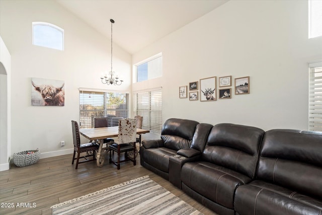 living room featuring a high ceiling, hardwood / wood-style floors, and a notable chandelier