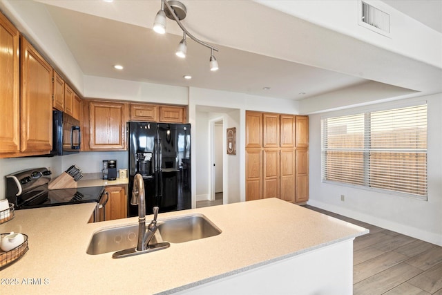 kitchen with sink, black appliances, and kitchen peninsula