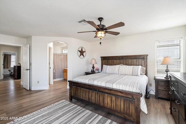 bedroom with dark hardwood / wood-style flooring, connected bathroom, and ceiling fan