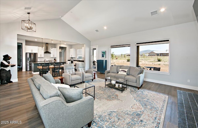 living room with high vaulted ceiling, dark hardwood / wood-style floors, and a notable chandelier