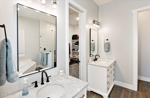 bathroom featuring walk in shower, vanity, and wood-type flooring